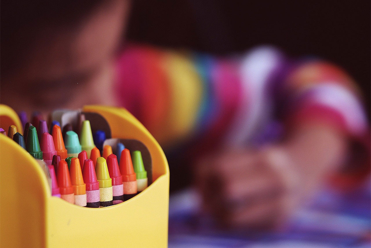 Criança colorindo com lápis de cera